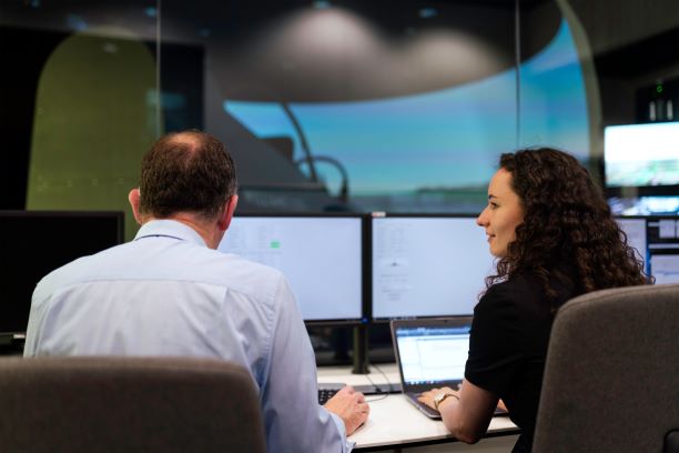 two corporate professionals shown working on computers in a corporate setting