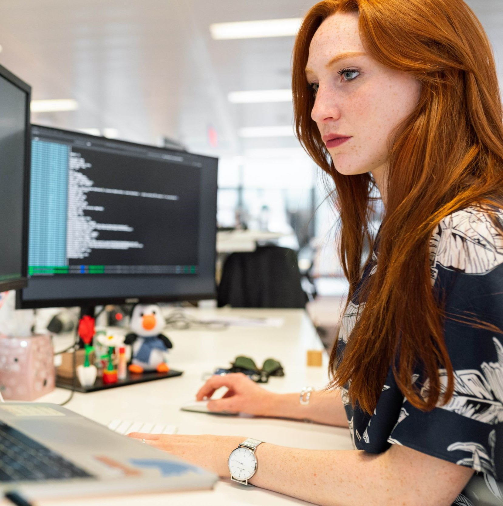 young professional shown coding at a desk